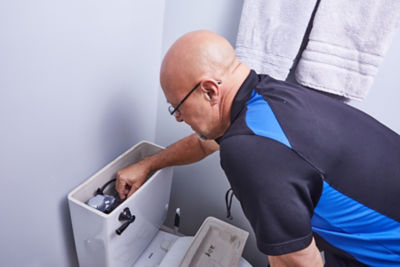 Plumber fixing a toilet in an Atlanta area home