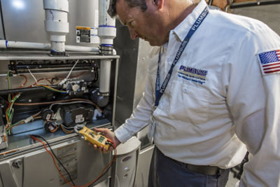 HVAC tech tuning up a furnace in a Denver area home