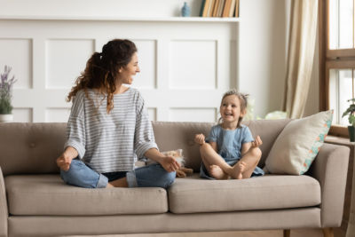 mother and daughter sitting on couch enjoying cool air 